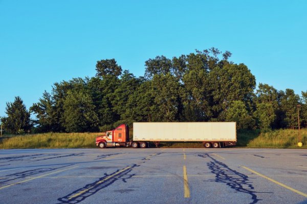 semi parked on the side of a parking lot